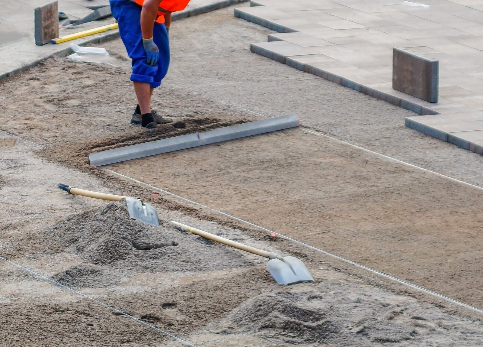 vecteezy_the worker evenly distributes crushed stone tool_73338936 scaled